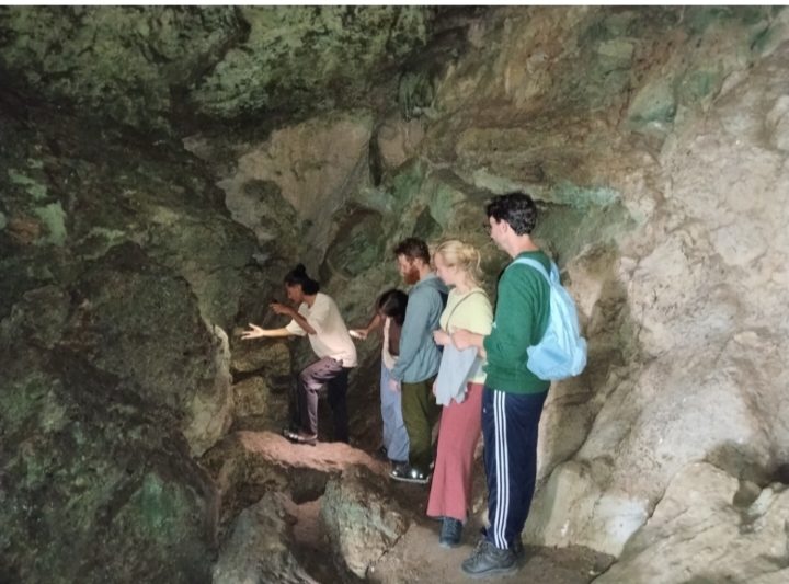 Turis asal Eropa bersama dengan pemandu wisata Liang Bua sedang menyaksikan lubang kecil yang sangat dalam di gua Liang Bua