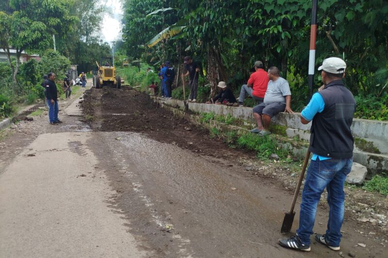 Sejumlah warga bersama Pemerintah kelurahan Watu sedang membersihkan urukan tanah di badan jalan samping Kantor Lurah Watu. (Foto: Fajar NTT/Nal Jehaut).